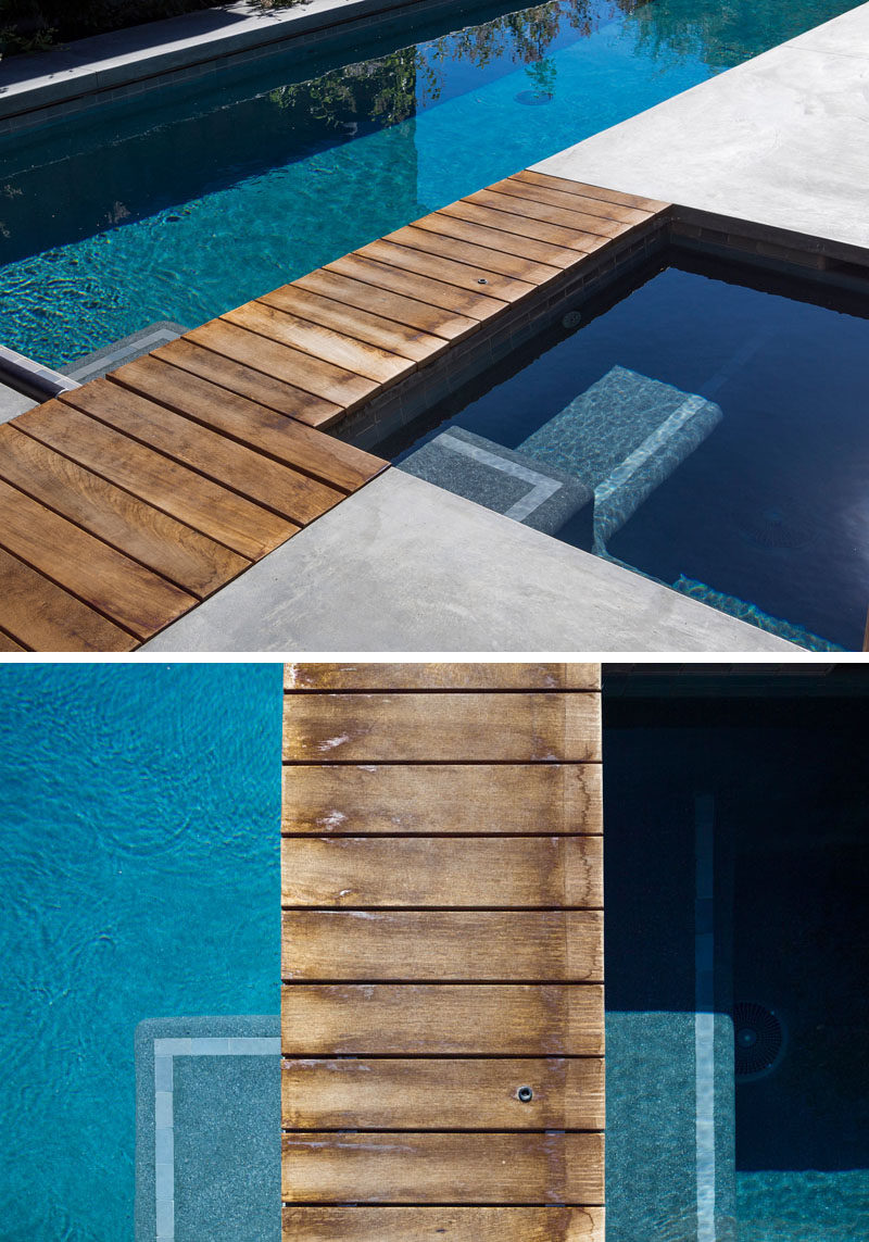 A small wooden walkway makes it easy for someone to walk between the pool and spa. #WoodPath #SwimmingPool #WoodWalkway