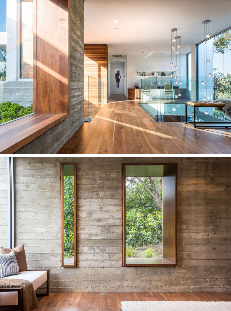 This modern house has a small bridge with glass guardrails that leads to the bedrooms. The window next to the bridge features a deep wood frame that's wide enough to sit on. #Windows #InteriorBridge #InteriorDesign