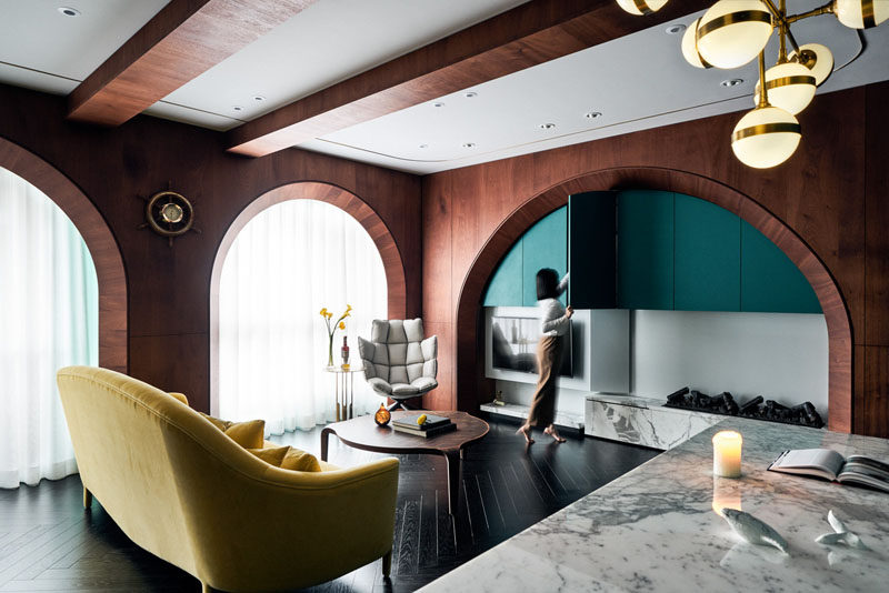 In this modern apartment, a curved arch defines the entertainment center, creates a space for storage and provides a home for the fireplace. The couch can be easily positioned for watching a movie or placed against the windows for a more open floor plan. #Wood #Arches #ModernInterior #ApartmentDesign #InteriorDesign