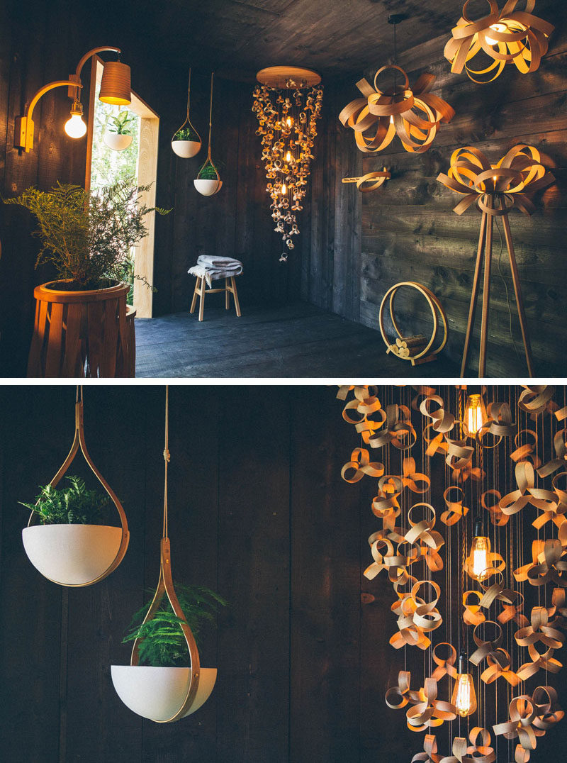 Dark wood covers the interior of this Tom Raffield garden show pavilion, which helps to highlight the bent wood lighting designs, planters and furniture. #Lighting #Planters #ModernWoodLighting