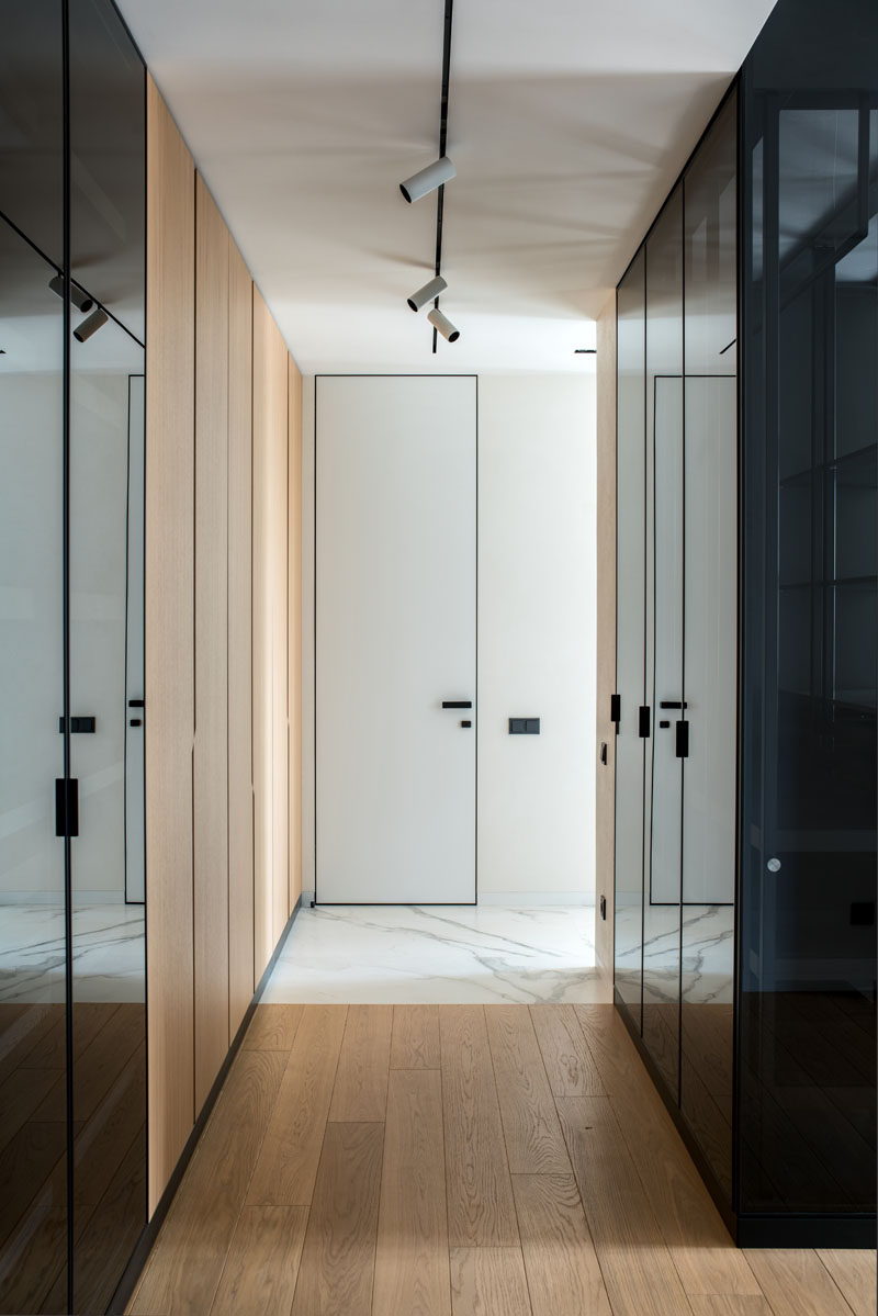 This master bedroom has walls of wood and black glass closets. #Closets #InteriorDesign