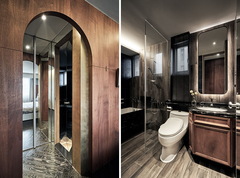 An archway in the bedroom provides access to the closet and the small bathroom. In the bathroom, a curved mirror is backlit for added light, and a glass shower screen allows the light from the windows to travel throughout the space. #Arch #BathroomDesign #InteriorDesign #MirroredCloset