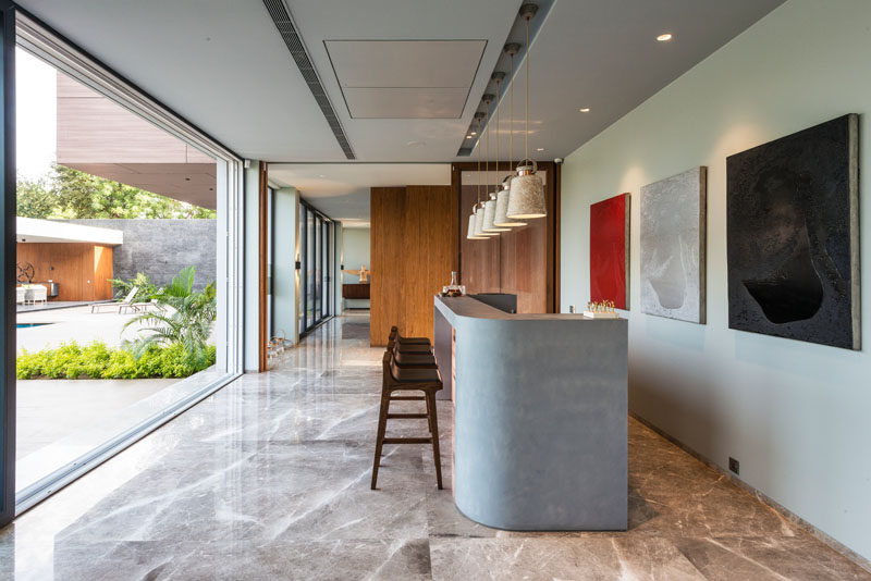 This modern home bar is finished in micro concrete with a copper front. #HomeBar #InteriorDesign