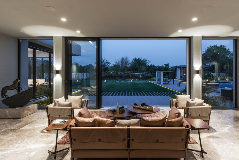 This contemporary living room has sliding glass walls that open up the interior to the backyard. #LivingRoom #SlidingWall #InteriorDesign