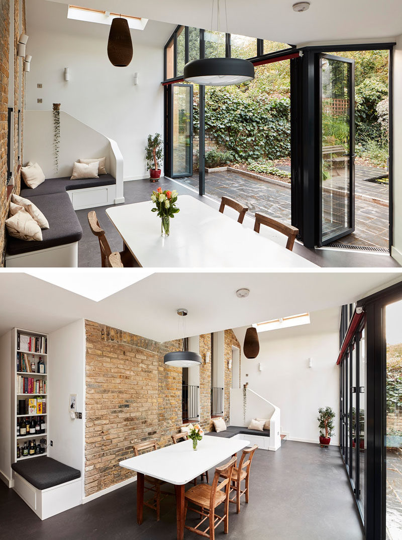 This modern house extension that has a sitting area, a dining area and a kitchen, opens up to the backyard with the use of folding glass doors. #ModernHouseExtension #ModernExtension #GlassWalls