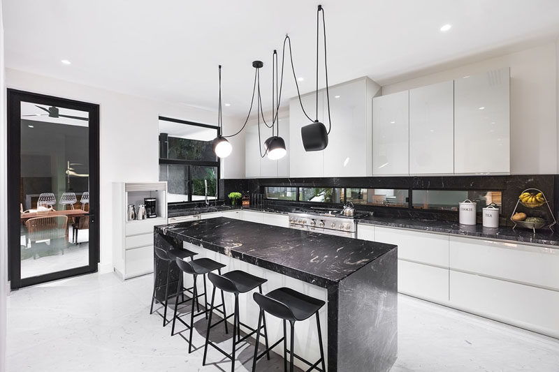 This modern kitchen is characterized by its black and white tones. #ModernKitchen #BlackAndWhite #KitchenDesign