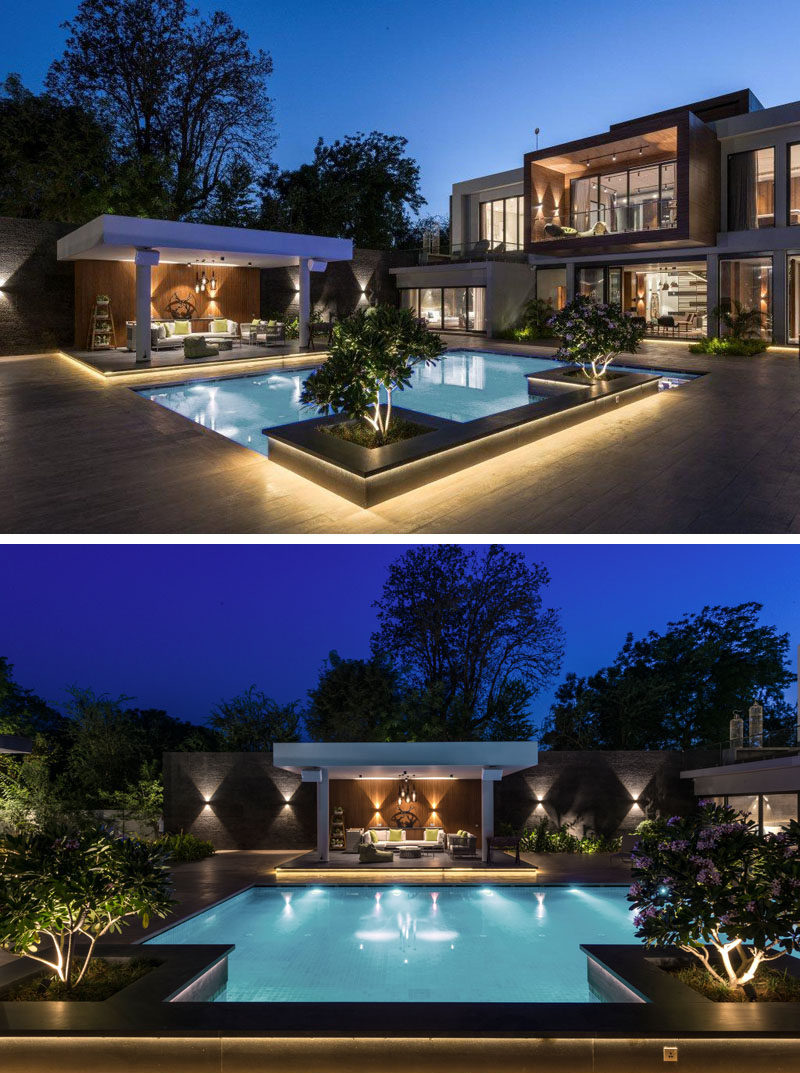 This modern house has a swimming pool with accent planters and a cabana. Hidden lighting has been used to create a luxurious atmosphere. #SwimmingPool #LandscapeDesign #Cabana