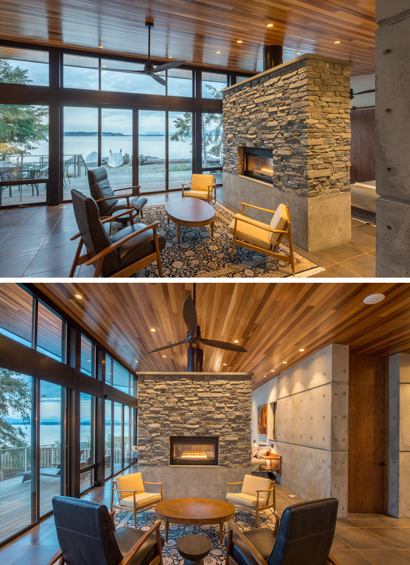 This modern waterfront cottage has a wood ceiling and stone work to bring a touch of nature inside. #Fireplace #StoneFireplace #BeachfrontCottage #WoodCeiling