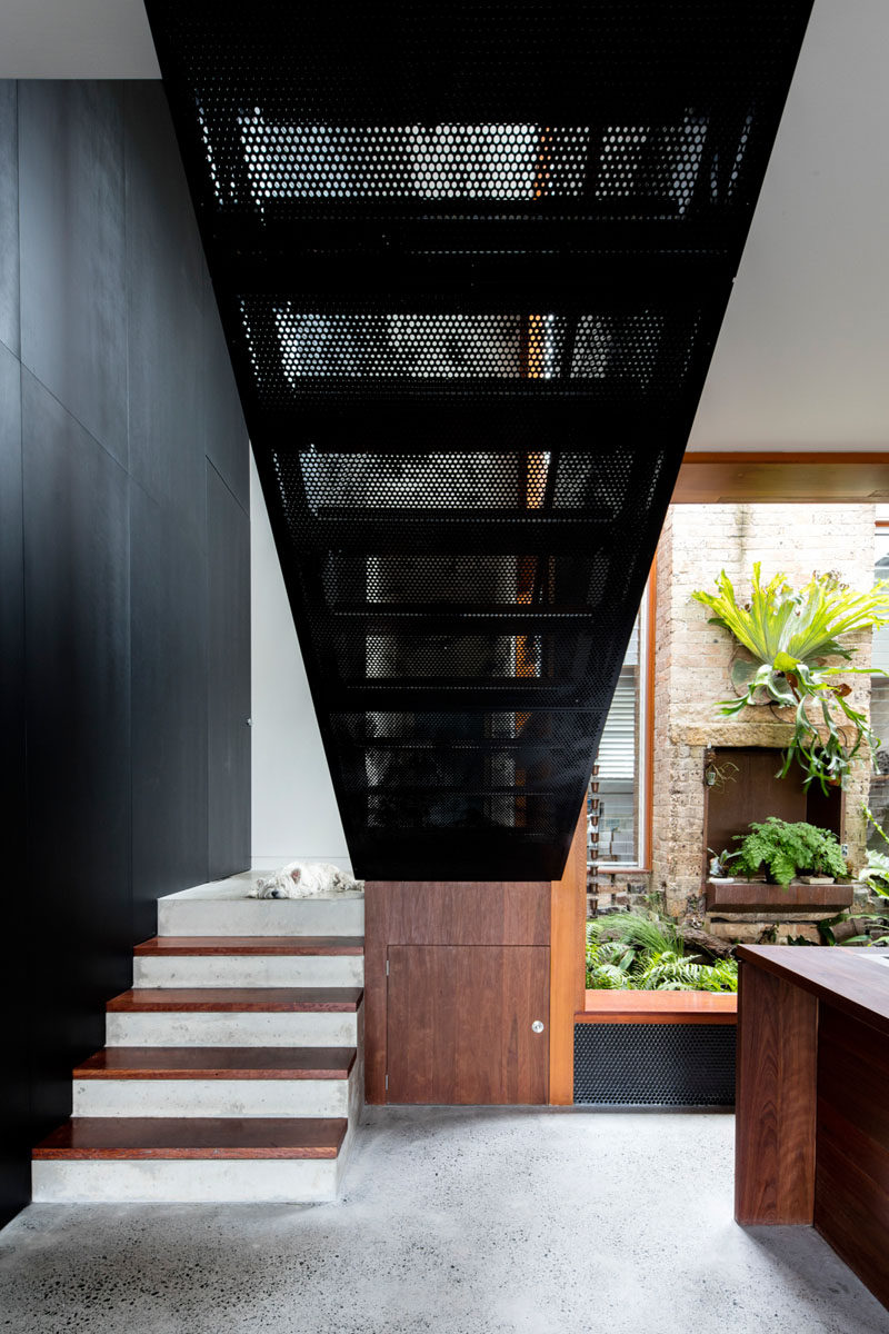 Wood, concrete and perforated metal stairs lead to the upper floor of this modern house. #Stairs #ModernStairs #StairDesign