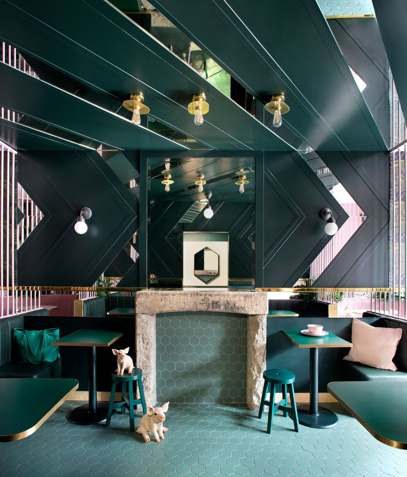 Contrasting materials have been used throughout this modern cafe, including geometric black and white prints, tiles, brass, velvet, leather,and lush planting, all adding to the intriguing design that changes as you move around the cafe. #CafeDesign #ModernCafe #InteriorDesign #Green