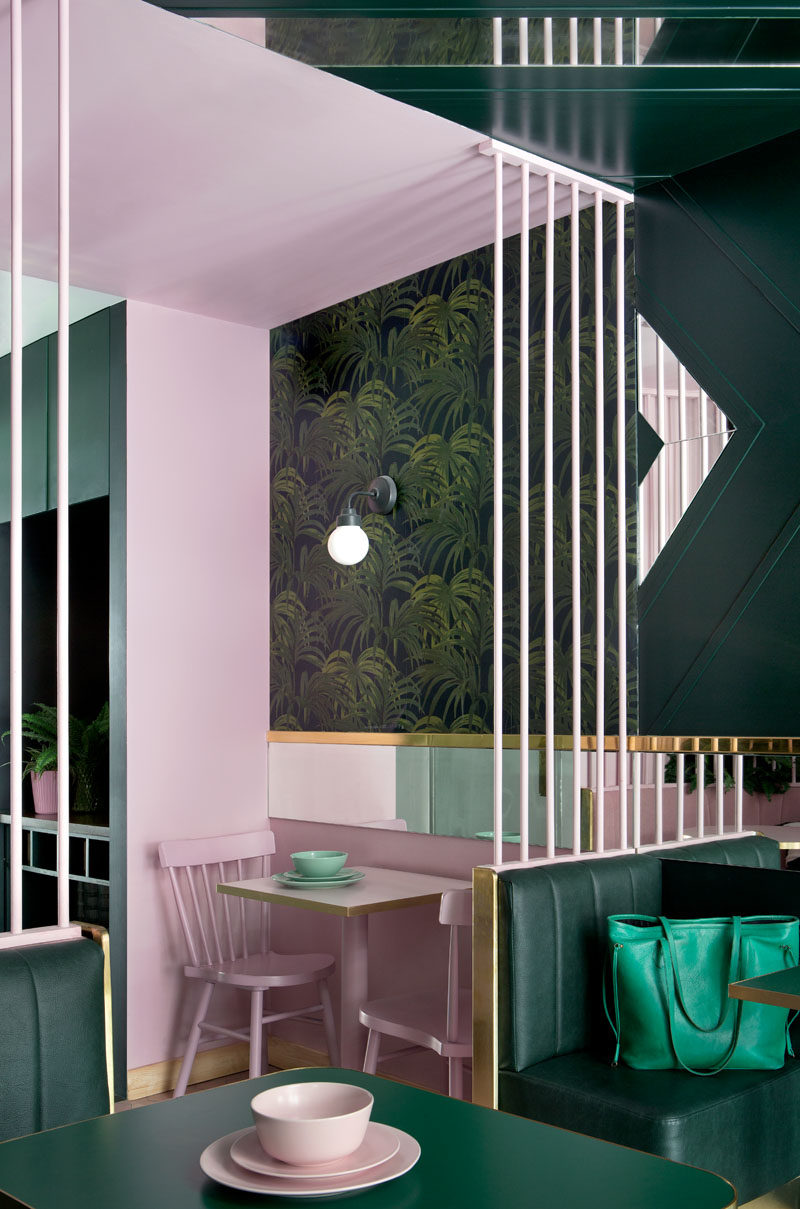 This green and pink modern cafe has a mixture of seating, with banquettes and smaller tables that can be enjoyed by individual diners and groups alike. #CafeDesign #InteriorDesign #ModernCafe