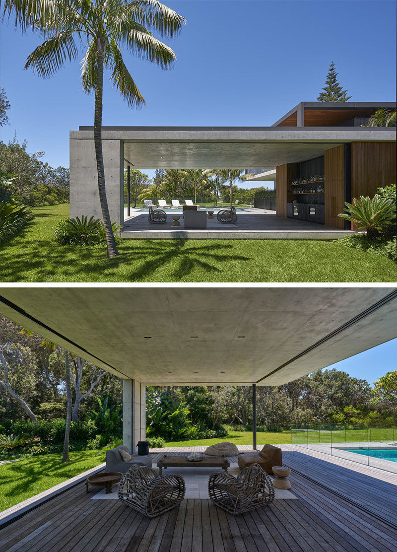 This modern house has a covered outdoor lounge area with a bar provides a place to enjoy the indoor / outdoor lifestyle by the pool, and if the weather turns, it can be closed off and protected from the elements. #ModernHouse #OutdoorSpace #OutdoorLounge