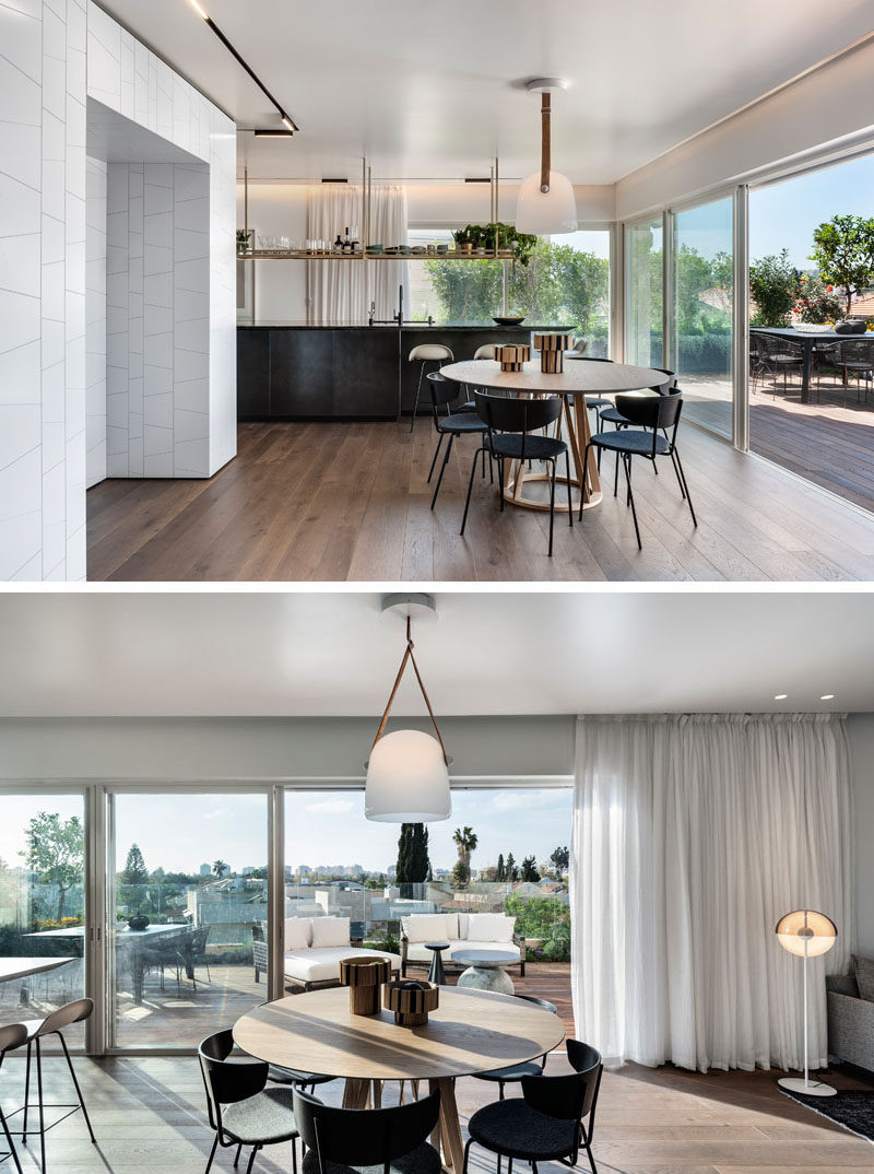 A round dining table is anchored in the room by a single pendant light in this open floor plan interior. #Apartment #DiningRoom #RoundDiningTable