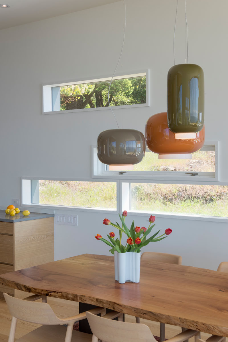 Small horizontal windows provide glimpses of the natural landscape outside. #Windows