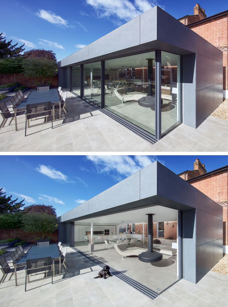 This modern extension has large double-glazed sliding doors that effortlessly open up to blur the distinction between inside and outside living areas. #Extension #SlidingGlassWalls #ModernAddition #Architecture