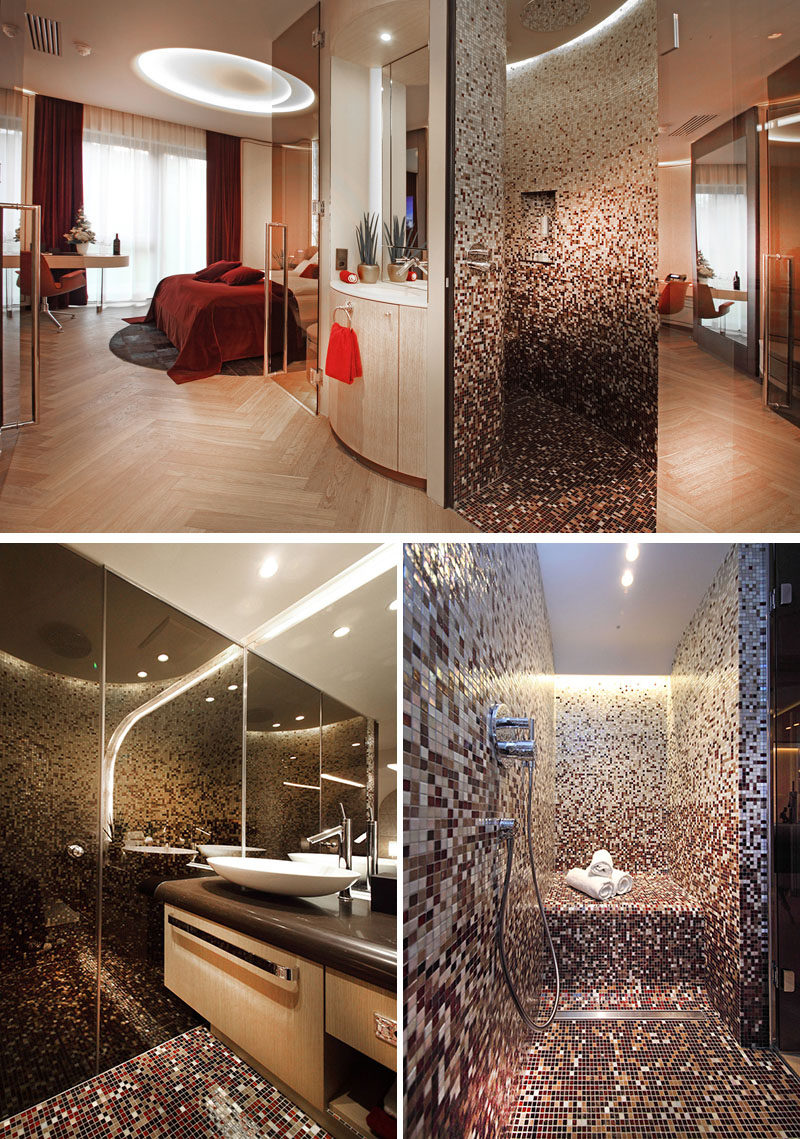 This modern hotel room has the bathroom hidden behind a curved wall, and a floor-to-ceiling tile mosaic covers the shower. #Bathroom #TileMosaic