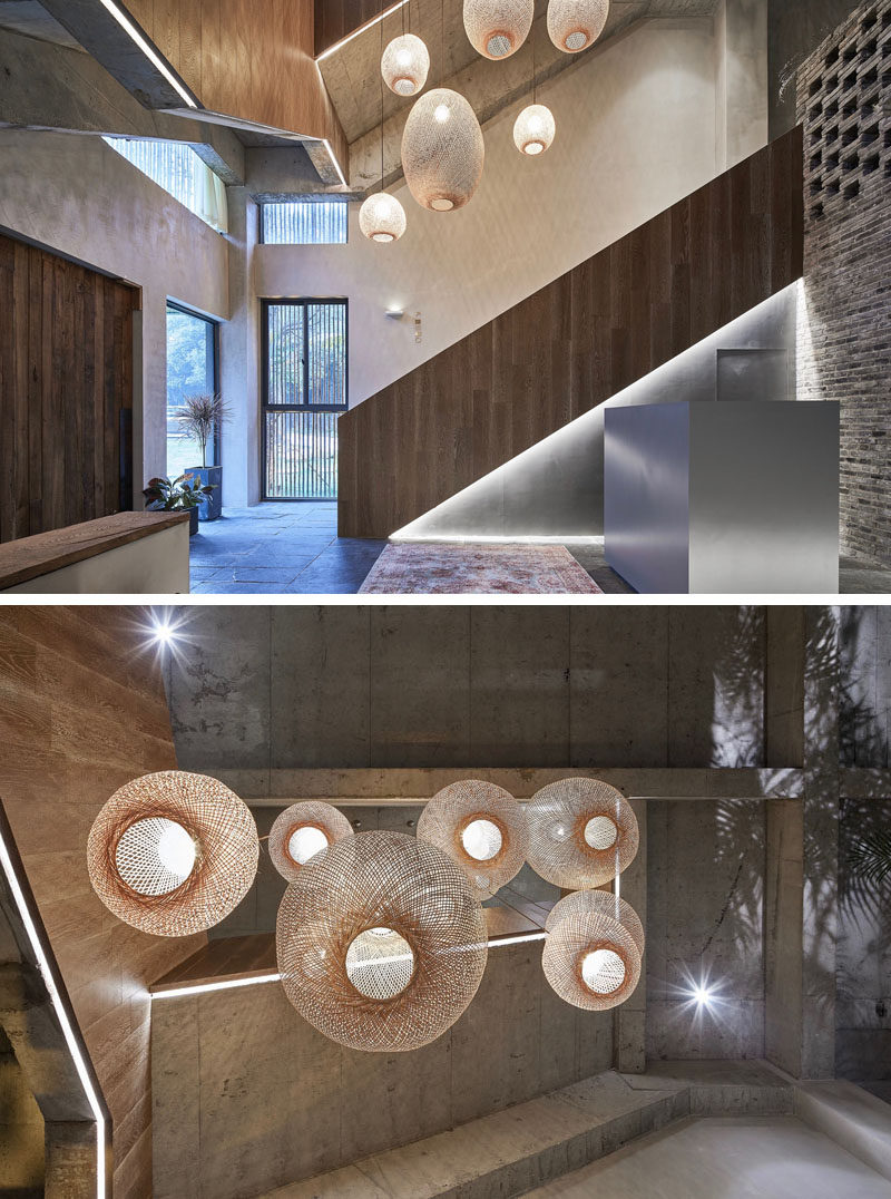 This modern hotel lobby is highlighted by a collection of woven pendant lights, while accent lighting outlines the shape of the stairs. #HotelLobby #HotelDesign #Lighting