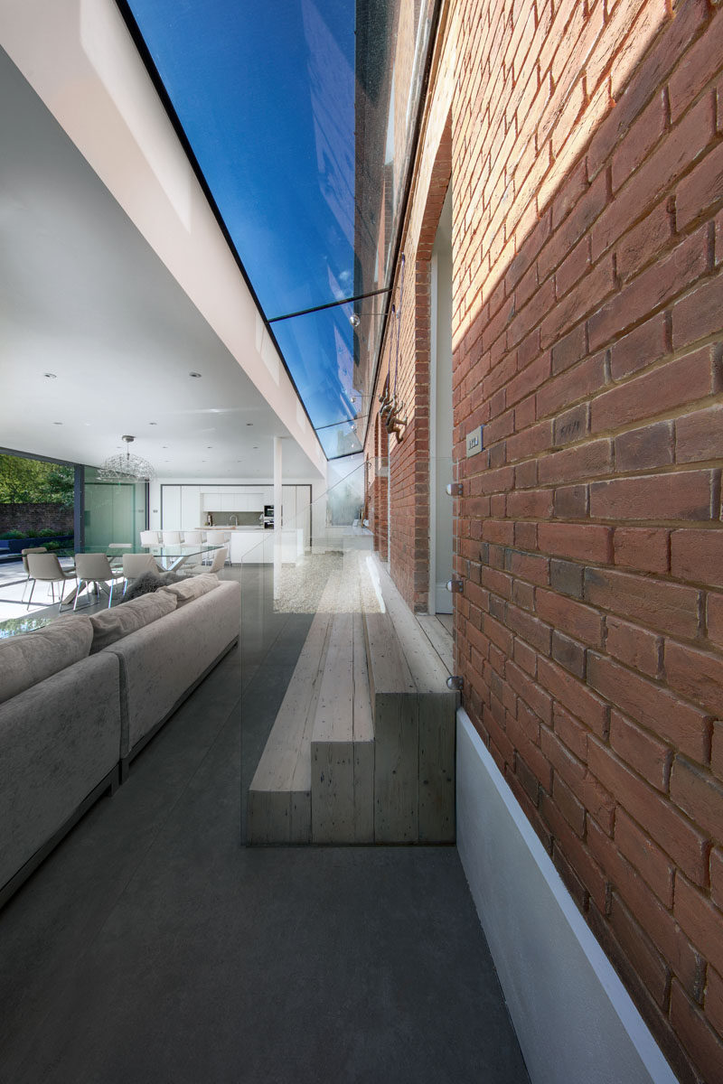 This modern extension features a 1.5m wide glass link that connects it to the original house, while three wooden steps make the transition between the two spaces easily accessible. #Skylight #Architecture #Stairs #Steps #Window #ModernExtension