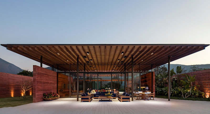 Bernardes Arquitetura have designed Casa Terra, a modern house in Itaipava, Rio de Janeiro, that features an expansive wood roof with walls made of pigmented concrete. #PigmentedConcrete #WoodRoof #Architecture #ModernHouse