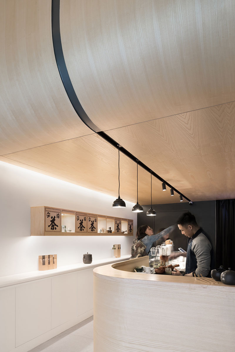 Upon entering this modern Japanese Tea House, visitors are guided straight under the curving timber ceiling where they can place their orders at the curved service counter. #CurvedWood #TeaHouse #RetailDesign