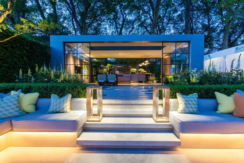 This garden features a sunken patio area with built-in seating, and a pavilion that houses a dining area and kitchen. #Landscaping #LandscapeDesign #Garden #Backyard