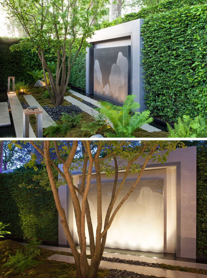 This small garden features an art piece that's surrounded by a large hedge. #ModernGarden #GardenDesign #Landscaping #LandscapeDesign