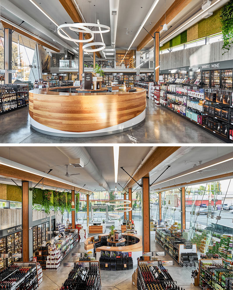 A curved wood tasting bar is centrally located within this modern liquor store. #TastingBar #RetailDesign #InteriorDesign #LiquorStore