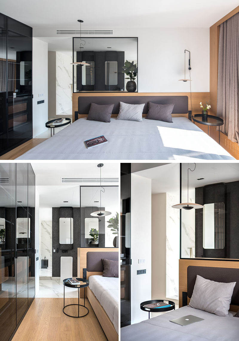 This master bedroom has a simple wood backdrop behind the bed, while transparent glass provides a view through to the ensuite bathroom. #BedroomDesign #MasterBedroom