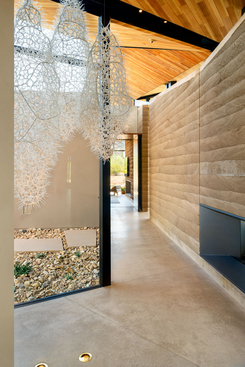 Materials such as layered walls of rammed-earth, wood, metal, and concrete, have been used throughout the design of this modern house. #Concrete #Wood #RammedEarth #Architecture