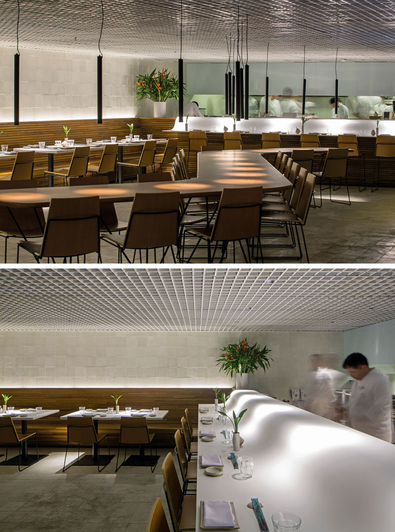 This modern restaurant features smooth Corian countertops, wood slat benches and a custom communal table. #RestaurantDesign #ModernRestaurant #InteriorDesign