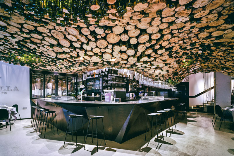 A Wavy Installation Of Cut Logs And Green Glass Cover The Ceiling Of ...