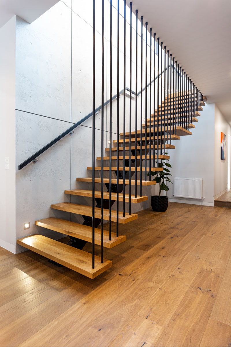 This modern open tread staircase has wood treads and a single metal stringer. #Stairs #ModernStairs #StaircaseDesign