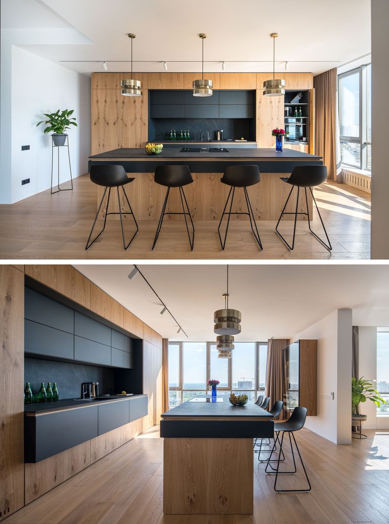 This modern kitchen has black cabinets and countertops that contrast the wood, while brass accents add a touch of glamour. #ModernKitchen #BlackAndWood #KitchenDesign