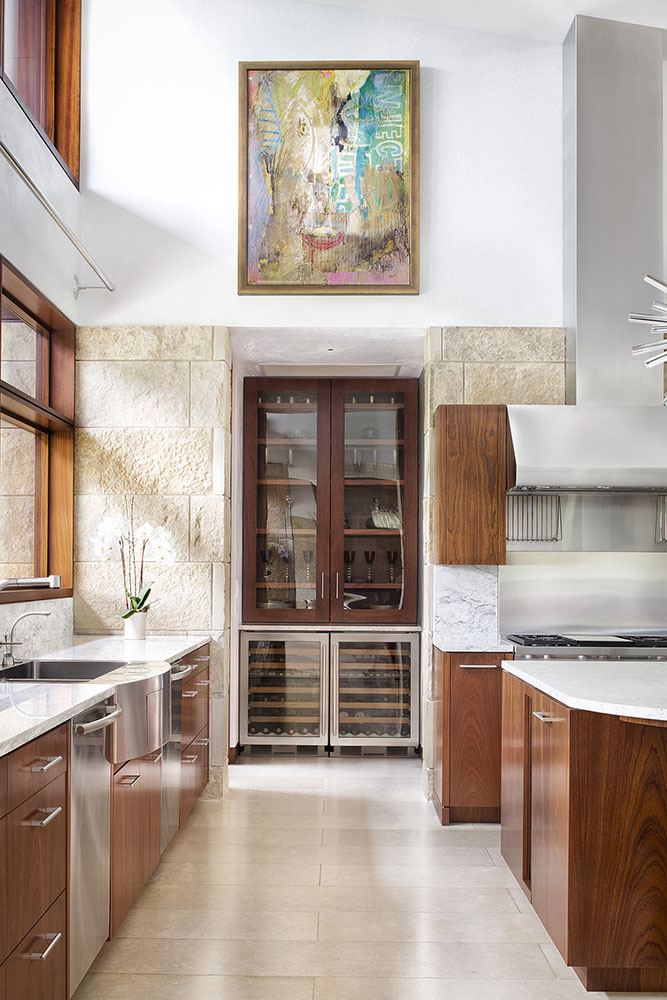 Tucked away into a small alcove in this modern kitchen, is a wine/bar area with storage and wine fridges. #WineStorage #Bar #KitchenDesign