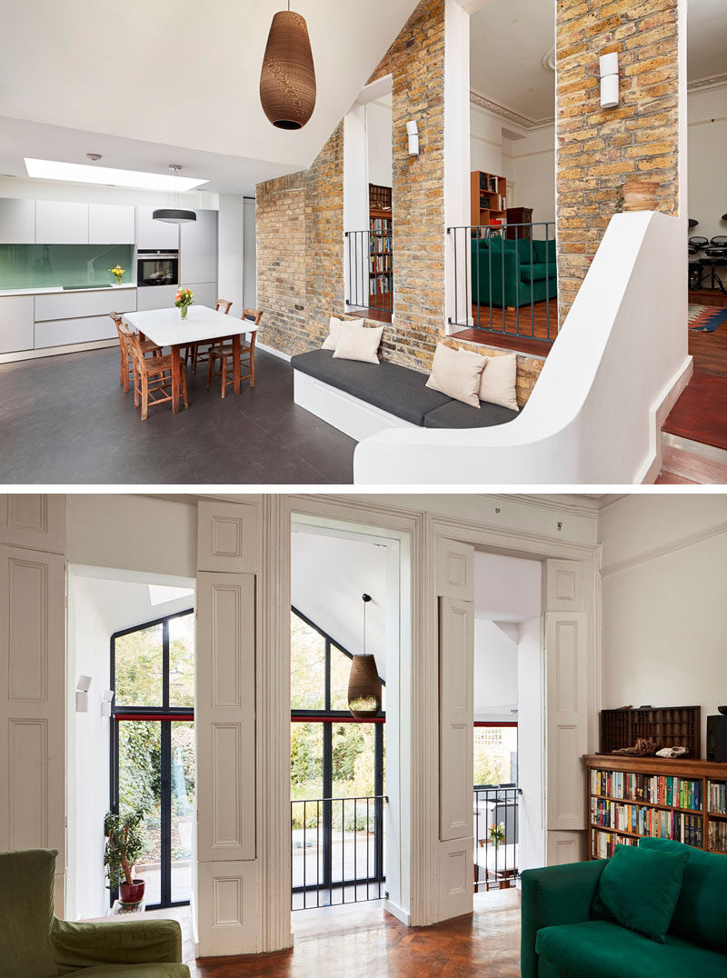 The original living room in this old Victorian home, now looks over the newly added living and dining space below. #BrickWall #ModernAddition