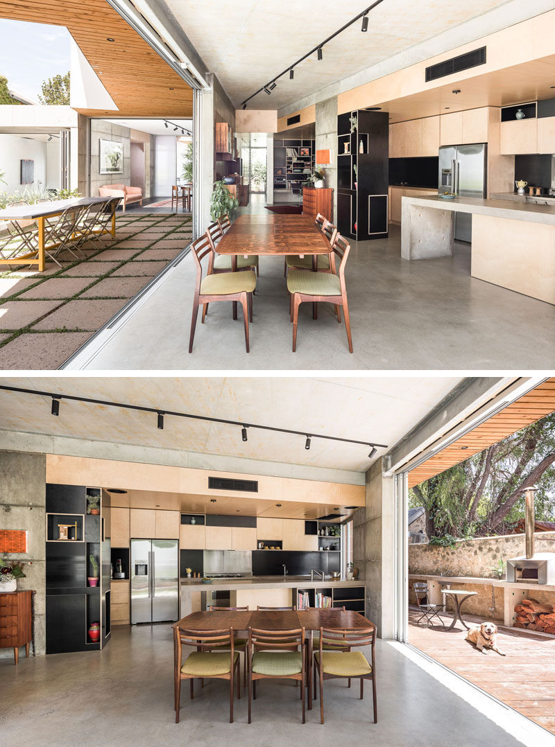 This house has an indoor/outdoor living environment, and in the kitchen, light wood cabinets have been combined with a concrete peninsula for a modern look. #Concrete #KitchenDesign #ModernKitchen #IndoorOutdoor