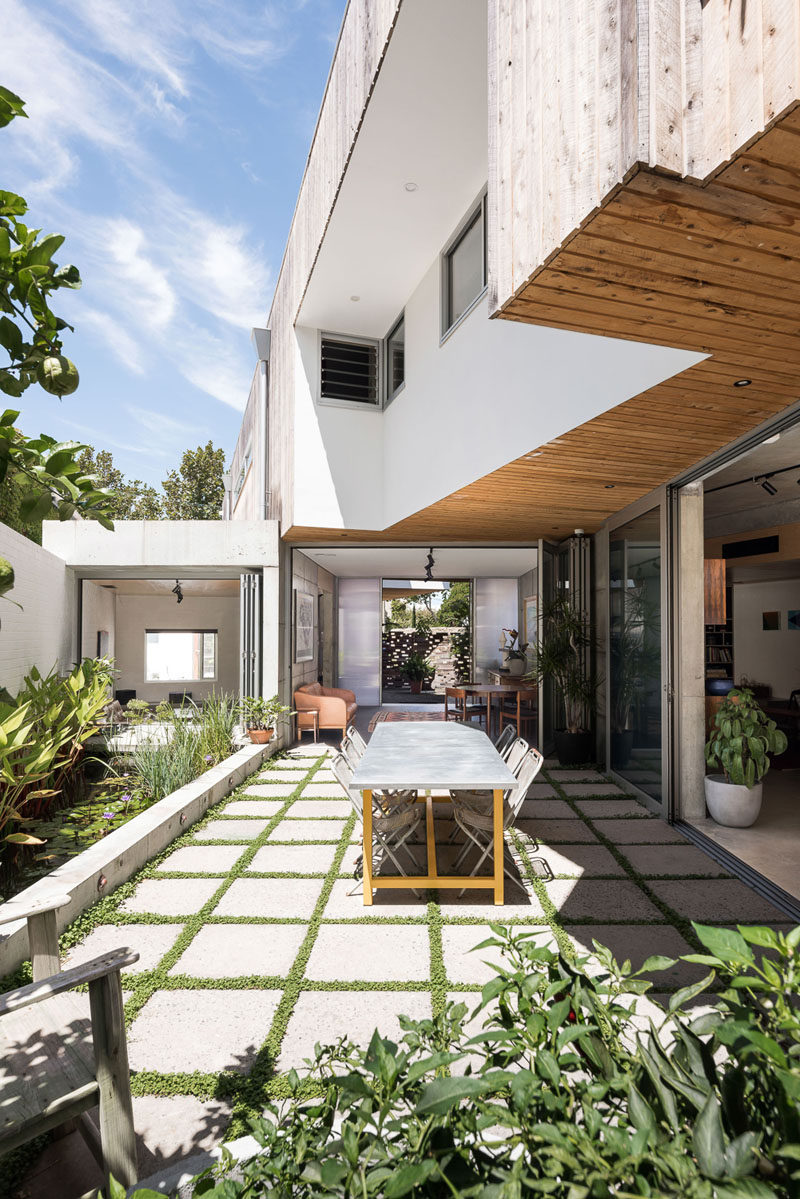 Large glass doors fold open to create an indoor / outdoor living environment for this modern house. #Patio #Pavers #Landscaping #Architecture