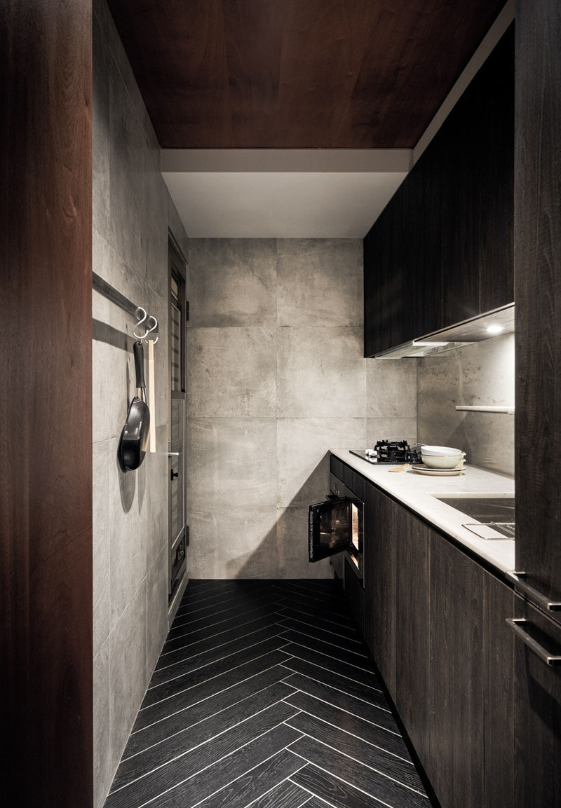 In this small kitchen, rich wood elements have been combined with large format tiles on the walls and herringbone patterned flooring. #SmallKitchen #KitchenDesign #HerringboneFloor #InteriorDesign