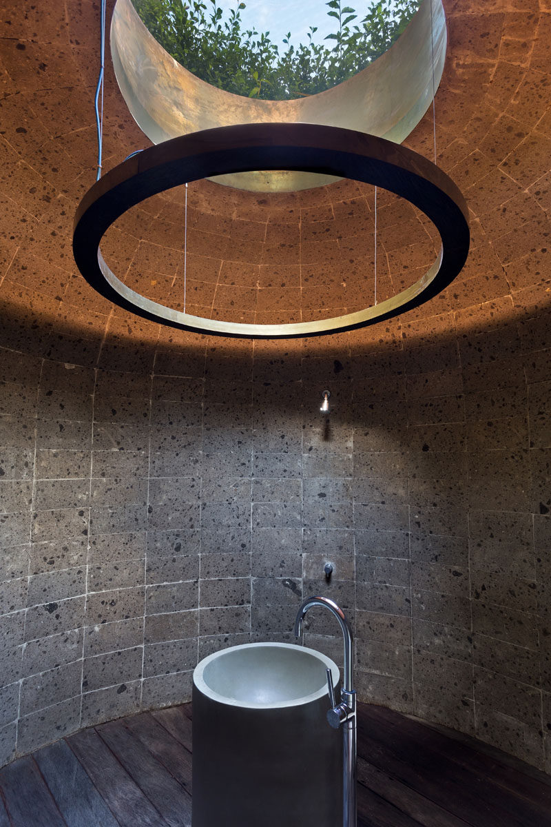 In this bathroom, the room is circular with a single round skylight that provides a view of the green roof and sky beyond. #Bathroom #CircularBathroom #Skylight