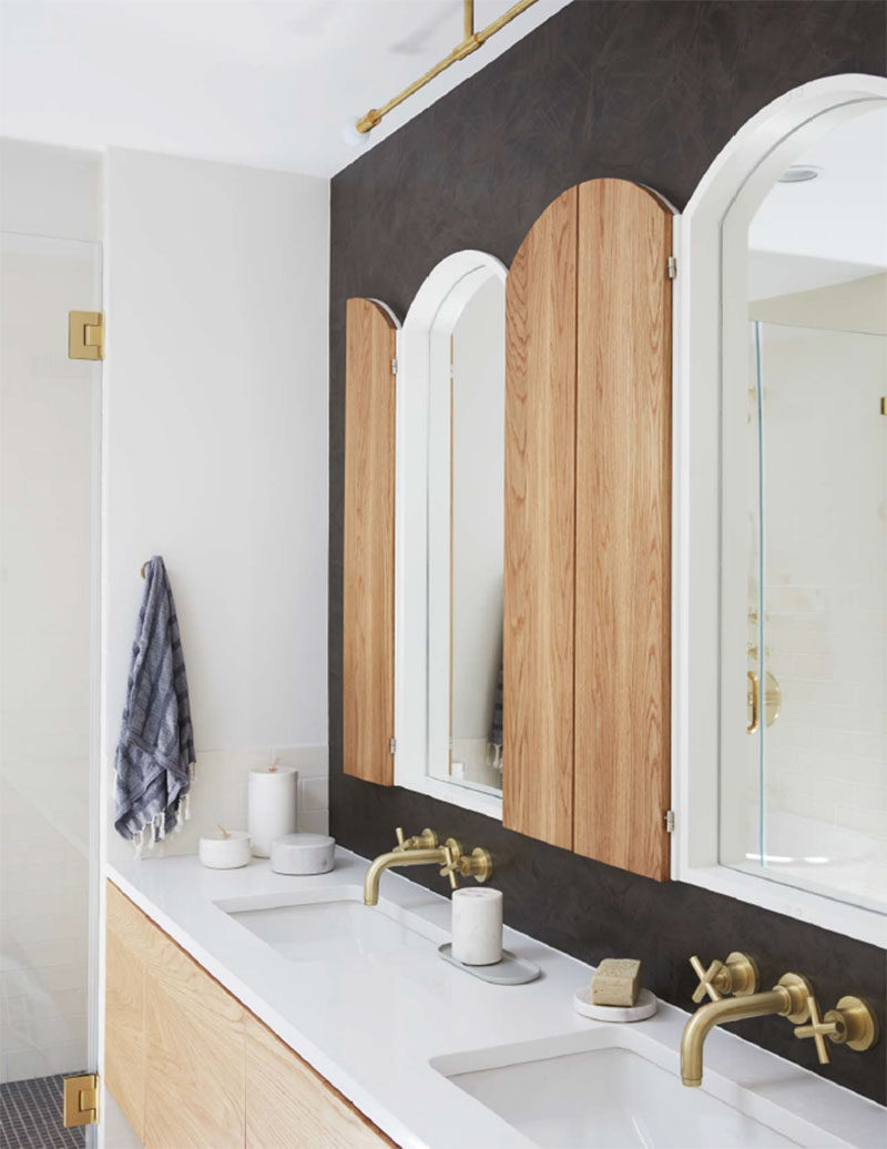 In this contemporary bathroom, a dark accent wall contrasts the white and light wood of the mirrors and the vanity. #Bathroom #ContemporaryBathroom #BathroomDesign