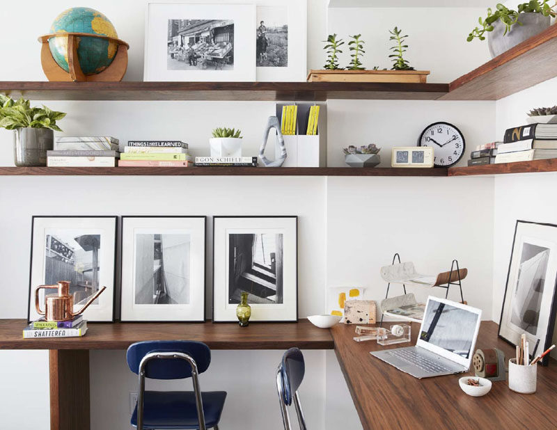 In this modern home office, wood shelves wrap around the corner of the room, while a matching desk provides enough space for two people to work. #HomeOffice #WoodShelves #Shelving #Desk