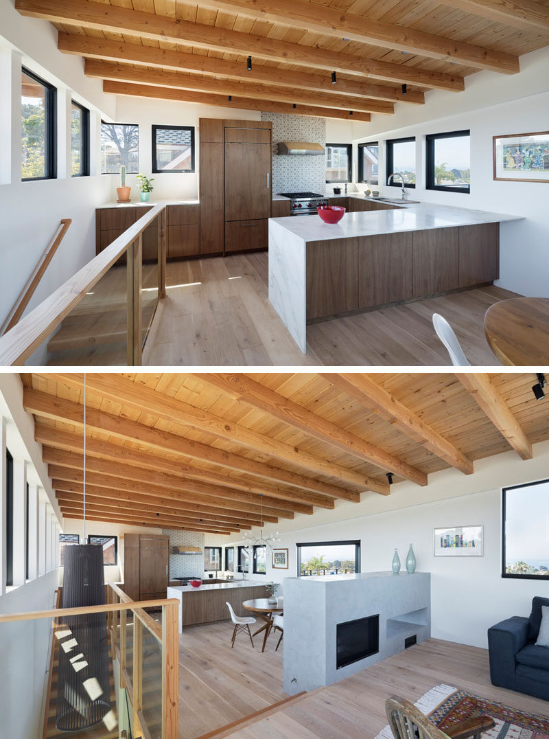 Upstairs, bright sunlit volumes are framed with contrasting geometrically tapered, dark metal windows.  #Kitchen #Windows #ModernInterior #ExposedWoodCeiling