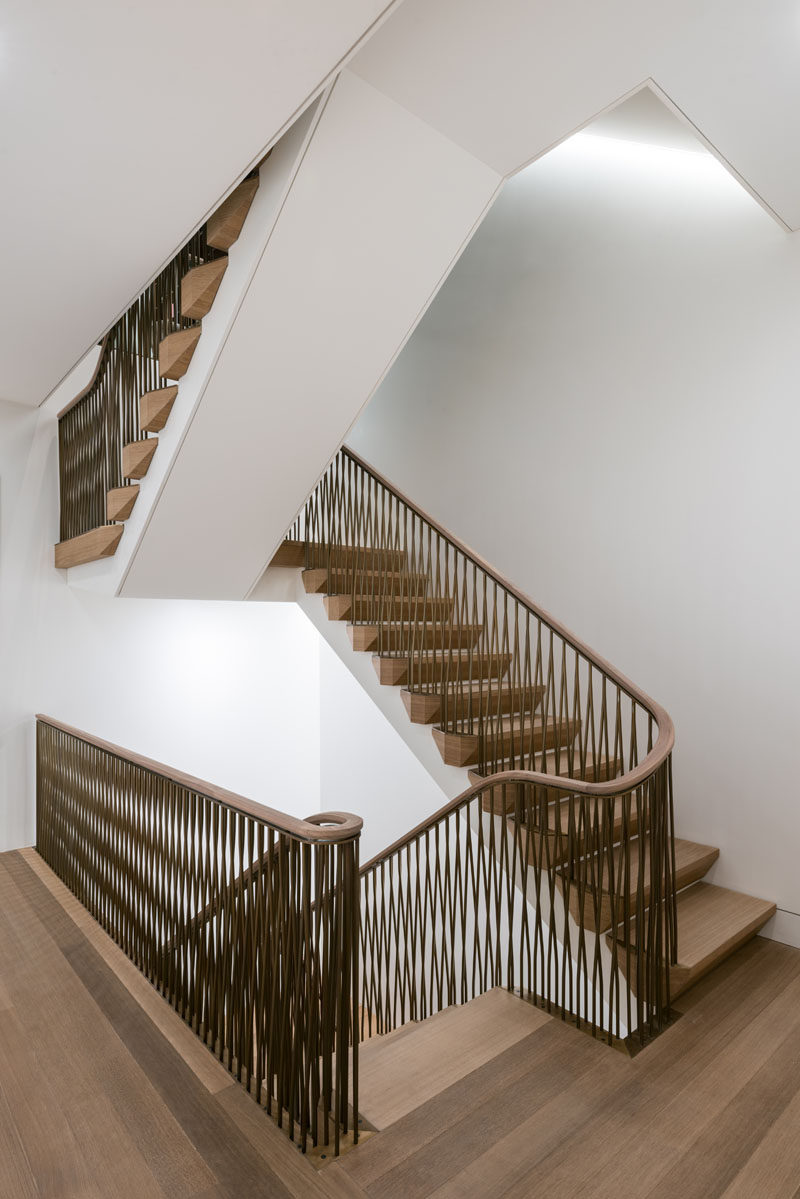 These modern wood stairs have an undulating and braided bronze railing. #Railings #BronzeRailings #Stairs