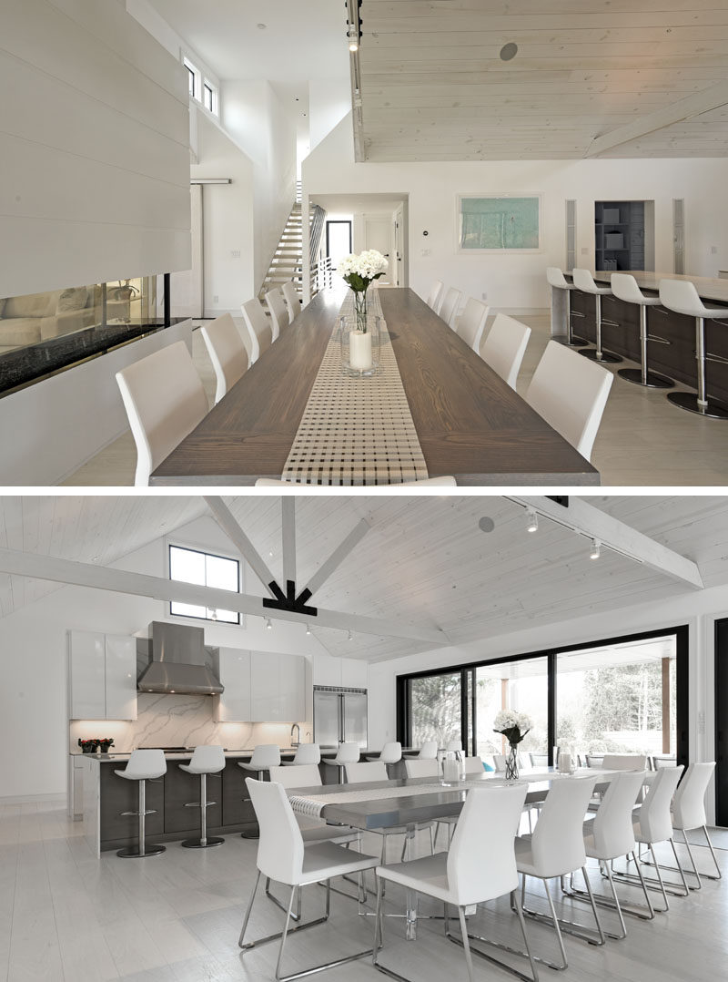 The entryway of this modern barn-inspired house opens up to a large open plan room, with the dining area and a fireplace separating the kitchen and living room. #DiningRoom #ModernDining #InteriorDesign