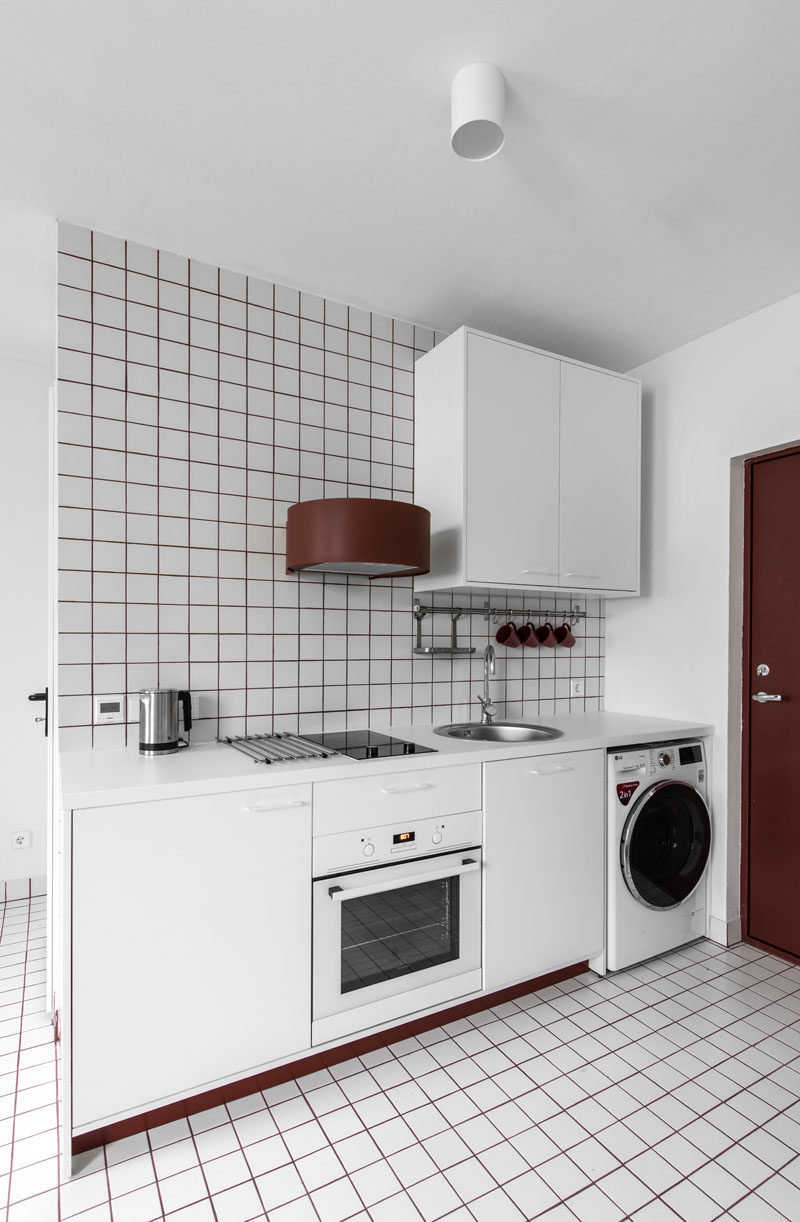 This small and white kitchenette uses red grout to add a pop of color. #Kitchenette #ModernKitchen #SmallKitchen #RedGrout