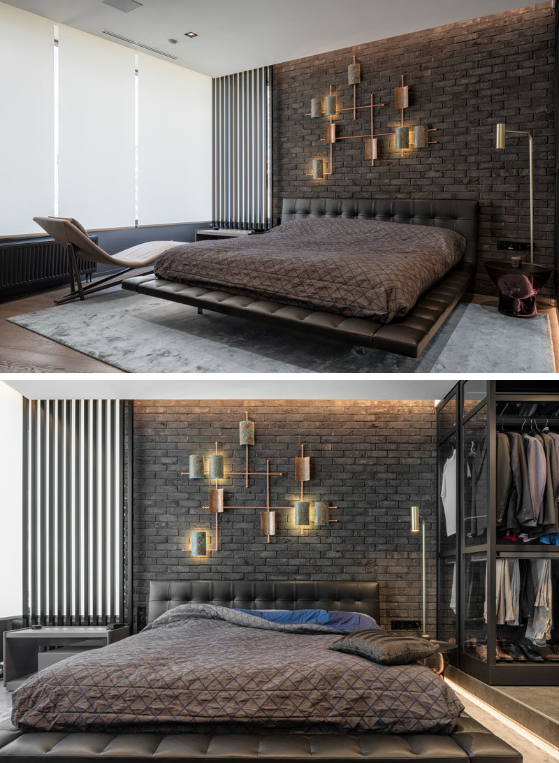 In this modern and masculine bedroom, a dark brick accent wall becomes a backdrop for a lighting sculpture. #Bedroom #ModernBedroom #DarkBrick