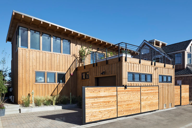 At the rear of this modern house is the garage, with the rooftop of the garage becoming the deck located off the dining room. #Garage #ModernHouse #RooftopDeck