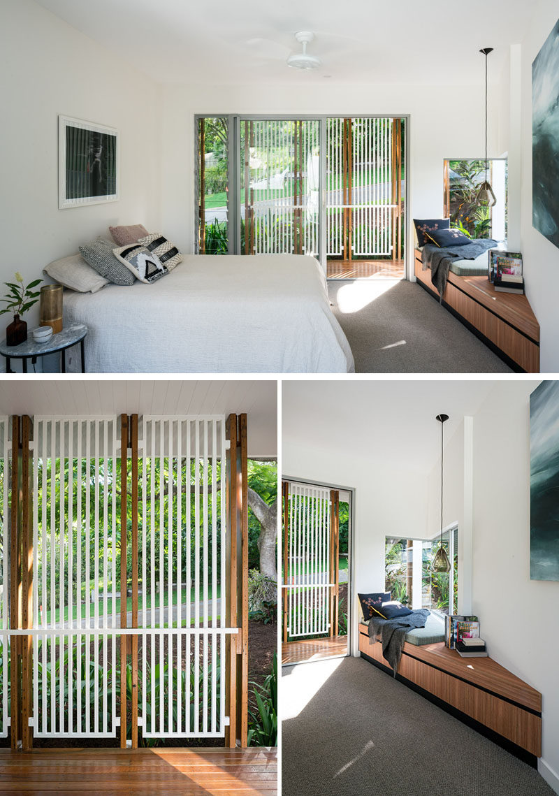 In this contemporary master bedroom, there's a built-in window seat that makes use of the corner, while a sliding glass door opens up to a small outdoor space with a privacy screen. #WindowSeat #ModernBedroom #BedroomDesign