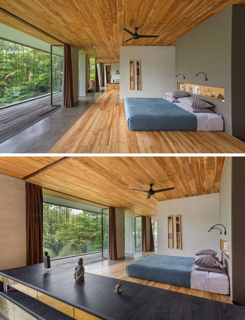 In this modern bedroom, a grey colored wall with a built-in shelf becomes the headboard for the bed, while wood features heavily on the ceiling and on the floor. #ModernBedroom #WoodCeiling #WoodFloor