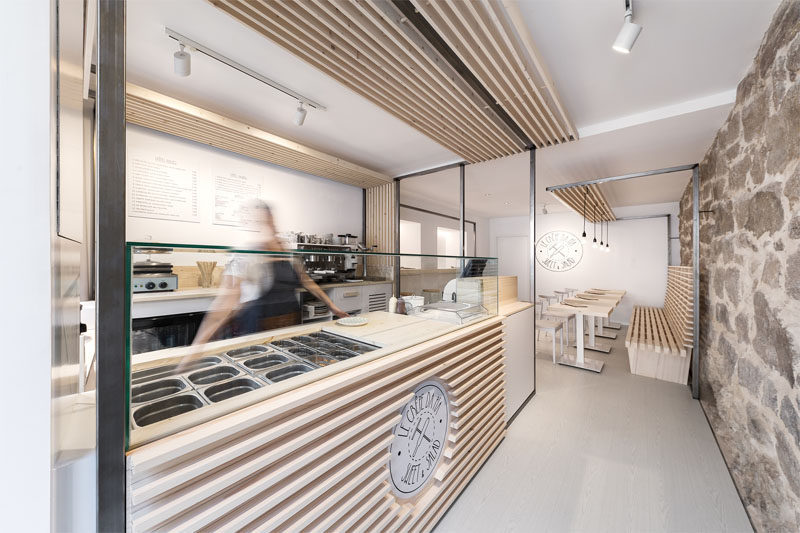 Erbalunga estudio have designed a creperie in Spain that combines original old stone, and new modern design elements. #Creperie #Cafe #RetailDesign #WoodSlats